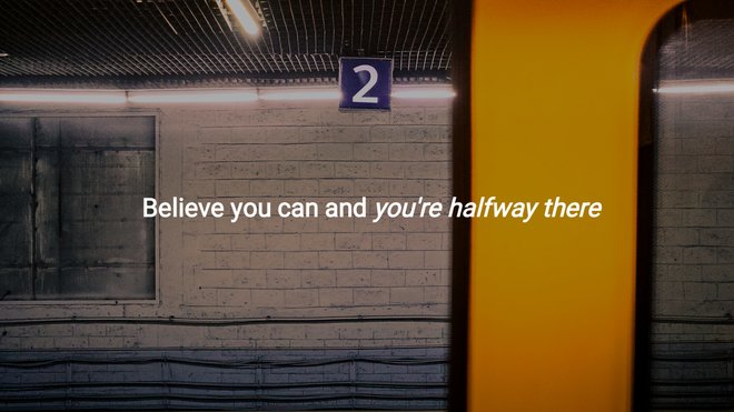 white subway car displays motivational quote against dim tunnel wall
